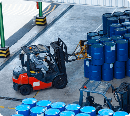 Forklift moving industrial drums in a warehouse